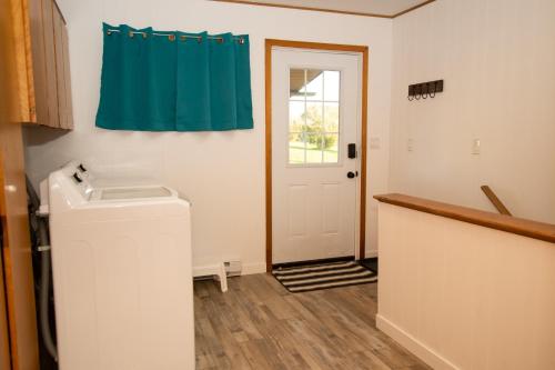 a laundry room with a washing machine and a door at La Maison Mavillette The Mavillette house 2BD in Mavillette