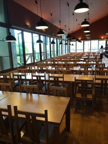 un restaurante vacío con mesas y sillas de madera en Aizu Kogen International Human Resources Center - Vacation STAY 44530v en Minamiaizu