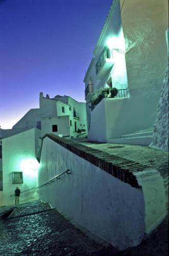 a person standing on the side of a building at night at Hotel Rural Almazara in Frigiliana