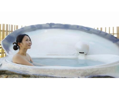 uma mulher sentada numa banheira em Reviews of Resort Hills Toyohama Soranokaze - Vacation STAY 78008v em Toba