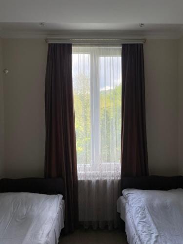 a bedroom with two beds and a large window at Zaali's wine cellar in Vani