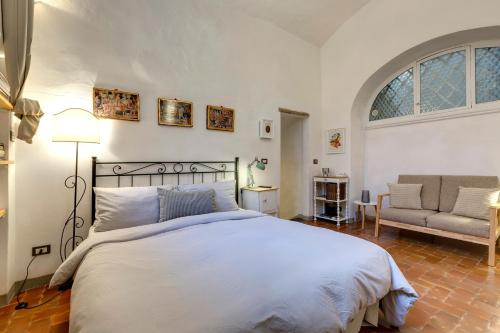 1 dormitorio con cama, sofá y ventana en Florence Holiday Homes Ponte Vecchio, en Florencia