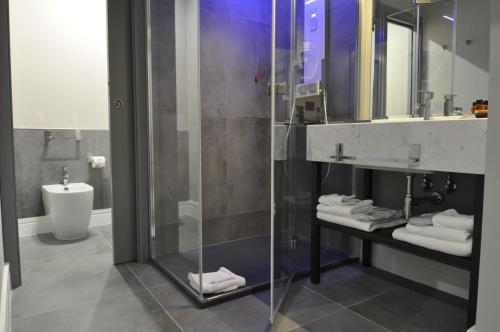 un bagno con doccia in vetro e lavandino di Place 24 Suites & Wellness a Roma