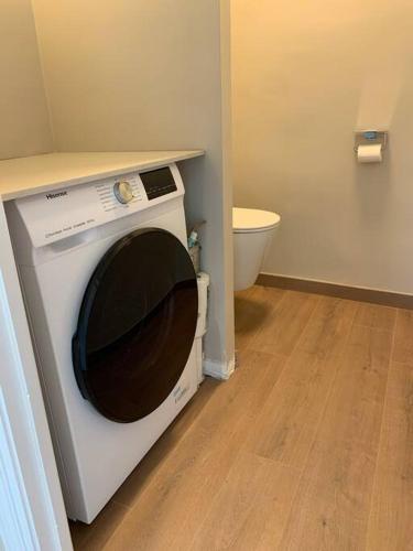 une machine à laver dans une salle de bain avec toilettes dans l'établissement Résidence le Concorde, à Le Touquet-Paris-Plage