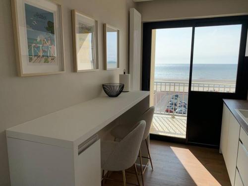 une cuisine avec un comptoir blanc et une vue sur la plage dans l'établissement Résidence le Concorde, à Le Touquet-Paris-Plage