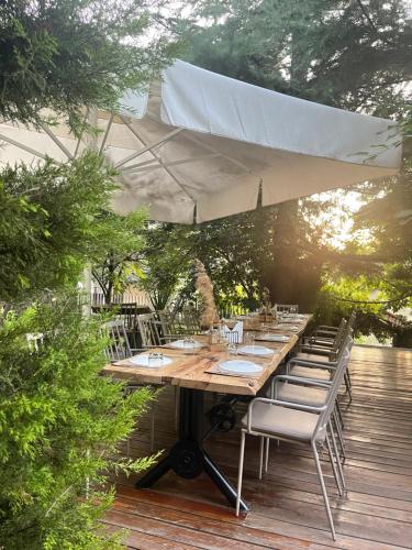 una mesa de madera y sillas en una terraza de madera en Dim's Hotel & Restaurant en Korçë