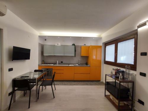 a kitchen with a table and a kitchen with orange cabinets at G&G House in Milan