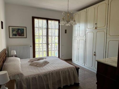 een slaapkamer met een bed en een groot raam bij Tra le Alpi Apuane e il mare in Montignoso