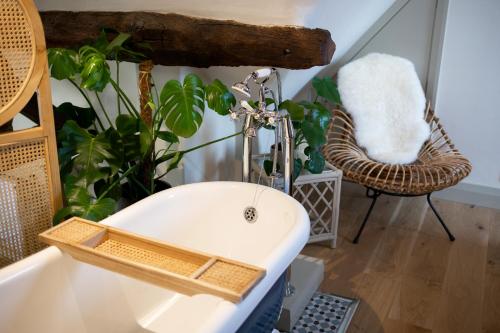 a bathroom with a sink and a chair with plants at The Forge - Beautiful Contemporary Barn - Hot Tub in Bridgnorth