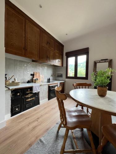 a kitchen with wooden cabinets and a table with chairs at Mountain View Apartment in Mieres