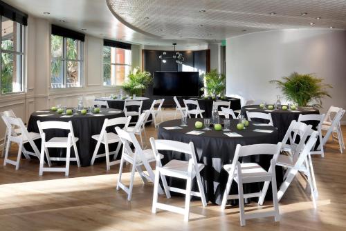 a room with tables and white chairs and a television at Meliá Orlando Celebration in Orlando