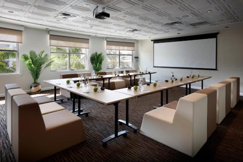 a conference room with a long table and chairs and a screen at Meliá Orlando Celebration in Orlando