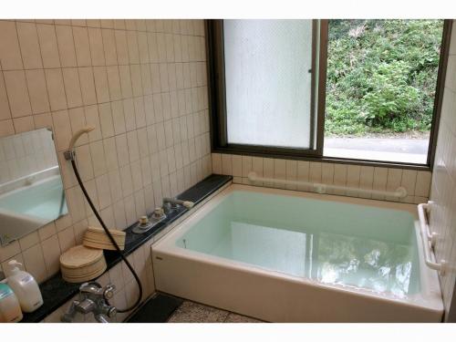 Blancart Misasa - Vacation STAY 14621v في Misasa: حوض استحمام في الحمام مع نافذة