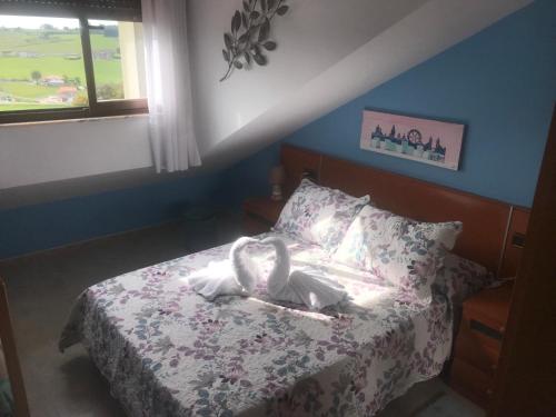a bedroom with a bed with two swans on it at Casa Villa Mey in Candás