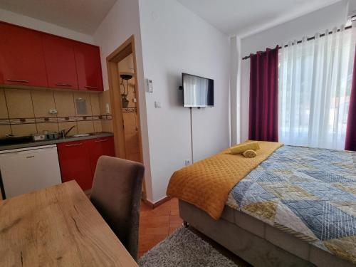 a kitchen and a bedroom with a bed and a table at Dom M Apartments in Budva