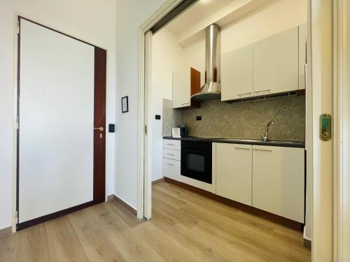 a kitchen with white cabinets and a sink and a door at Le Dimore del Corso in Catania