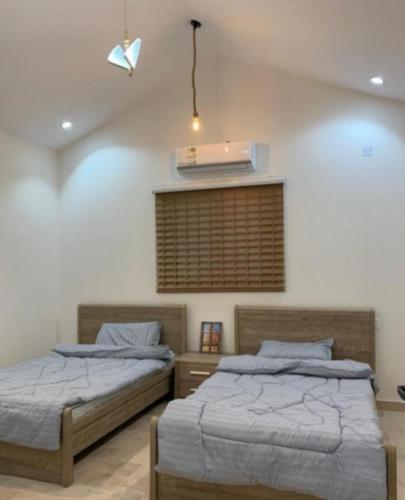 a bedroom with two beds and a air conditioner at منتجع مطل الريم in Taif