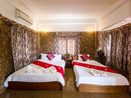 a bedroom with two beds with red and white sheets at Kep Villa Hill Guest House 1 in Kep