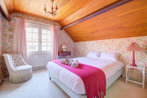 une chambre avec un grand lit et une chaise dans l'établissement Bois et chiffons famille et confort, à Siorac-en-Périgord