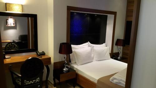 Un dormitorio con una cama, un escritorio y un espejo. en Apartments M Palace, en Budva