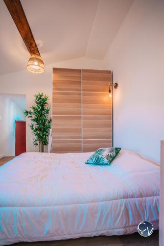 une chambre avec un grand lit avec une tête de lit en bois dans l'établissement Studio centre-ville (Ecusson), à Nîmes