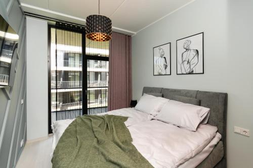 ein Schlafzimmer mit einem Bett und einem großen Fenster in der Unterkunft Liine apartment 3027 in Pärnu