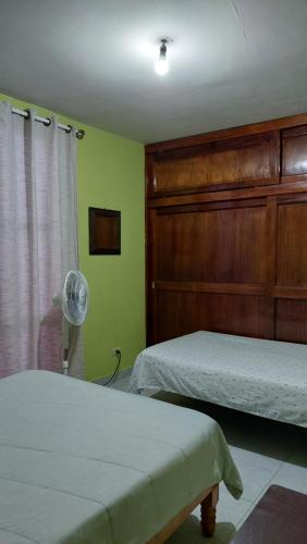 1 dormitorio con 2 camas y ventilador en RELAJACION SERCAS DEL AEROPUERTO 