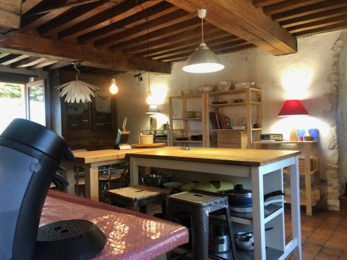 a kitchen with a counter and a table with stools at Grande maison familiale, rustique et charmante en Bourgogne, dans le Morvan in Dun-sur-Grandry