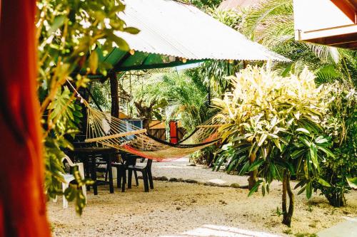 a hammock is hanging from a table and chairs at Surf Paradise in Santa Teresa Beach
