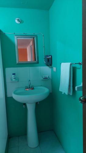 Baño azul con lavabo y espejo en RELAJACION SERCAS DEL AEROPUERTO 