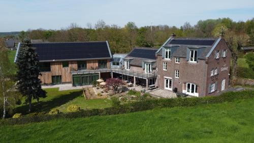 een luchtzicht op een groot huis met zonnepanelen erop bij Hof van Kleeberg in Mechelen