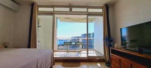 - une chambre avec un lit et une grande fenêtre avec vue dans l'établissement FARE NATIHERE, à Papeete