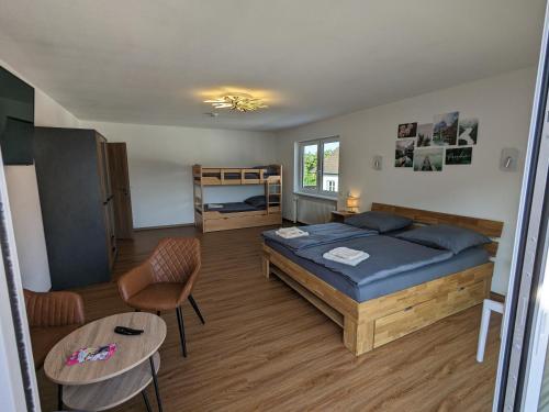 een slaapkamer met een bed en een tafel en stoelen bij S'bahnhöfle Apartments in Ringsheim