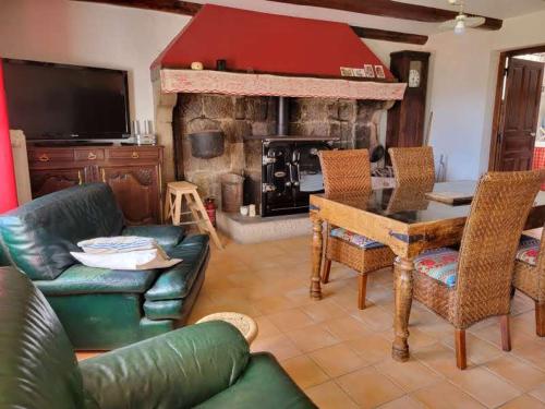 un salon avec une table et une cheminée dans l'établissement Se reconnecter à la nature au gîte 3 étoiles de Montager à Saint André de Chalencon, à Saint-André-de-Chalençon