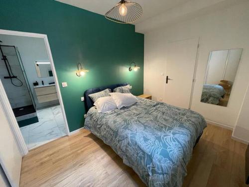 a bedroom with a bed and a green wall at Appart 1 chambre neuf confort in Rouen