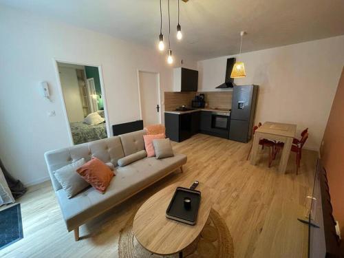 een woonkamer met een bank en een tafel bij Appart 1 chambre neuf confort in Rouen