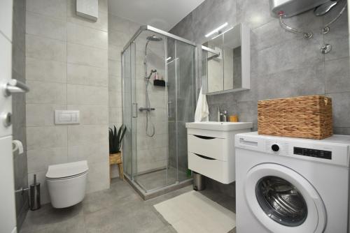 a bathroom with a washing machine and a shower at Apartman Leutar in Trebinje