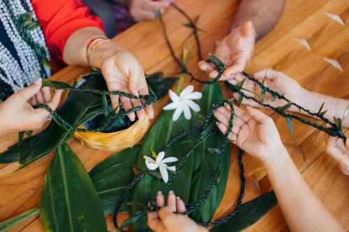 un grupo de personas sosteniendo flores blancas en una mesa en The Westin Hapuna Beach Resort en Hapuna Beach