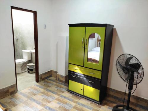 a green cabinet with a fan in a room at Hostal Casa La Candelaria in Mompós
