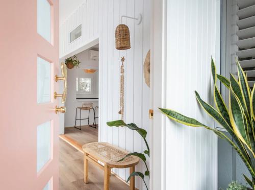 a hallway with a chair next to a door at Sea Breeze Cottage - oceanstays in Yamba