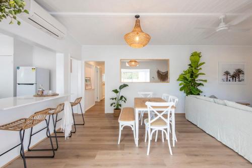 a kitchen and dining room with a table and chairs at Sea Breeze Cottage - oceanstays in Yamba
