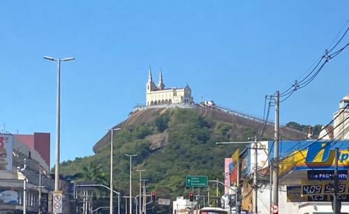 un edificio en la cima de una colina con una casa en él en KITNET MOBILIADA - PENHA, en Río de Janeiro