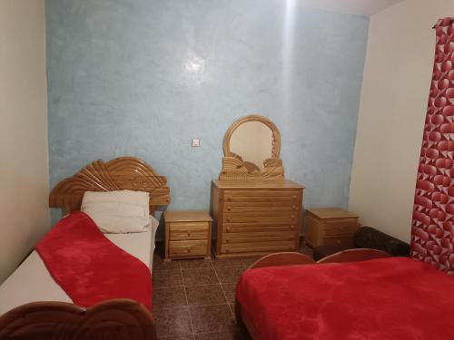 Habitación con 2 camas, cesta y mesa. en Dar badiawarda, en Azilal