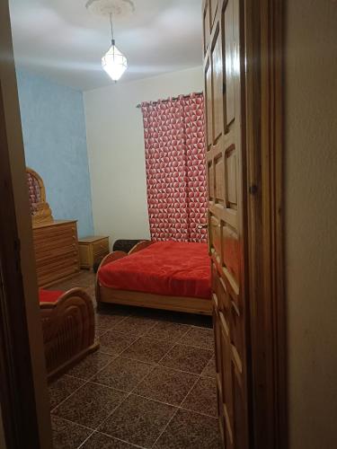 1 dormitorio con 1 cama roja en una habitación en Dar badiawarda, en Azilal