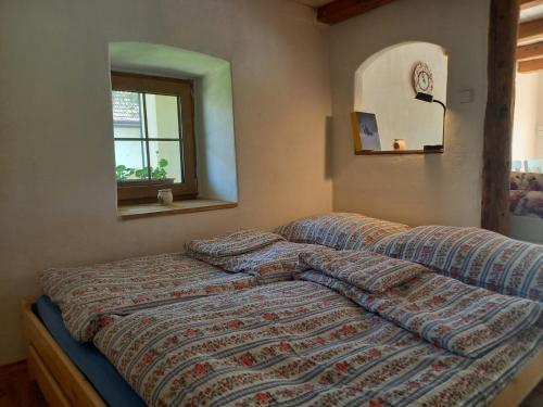 ein Bett mit einer Bettdecke in einem Schlafzimmer in der Unterkunft Wellness Vejminek na farmě u koní in Milešov