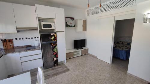 a white kitchen with a refrigerator and a microwave at Apartamento en Costacabana in El Alquián