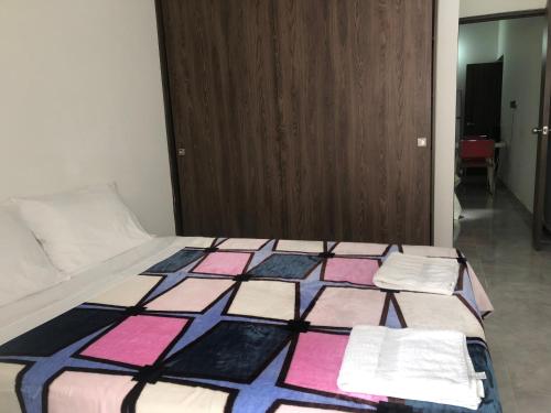 een slaapkamer met een bed met een kleurrijke quilt bij Apartamento cómodo, céntrico y bien ubicado apto 404 in Medellín