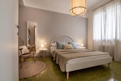 ein Schlafzimmer mit einem großen Bett und einem Stuhl in der Unterkunft Il Giardino tra Cielo e Mare in Porto Venere