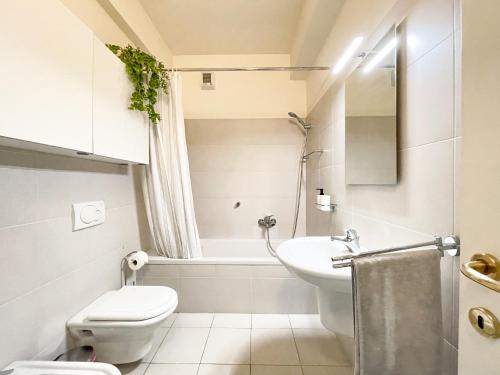a white bathroom with a toilet and a sink at Regina di Laglio - Free Parking, Garden, Lake View in Laglio
