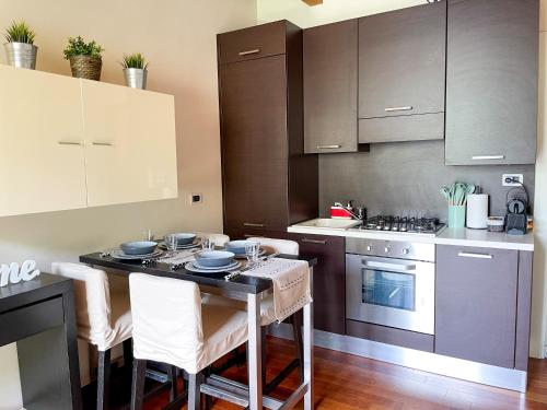 a kitchen with a table with chairs and a stove at Regina di Laglio - Free Parking, Garden, Lake View in Laglio